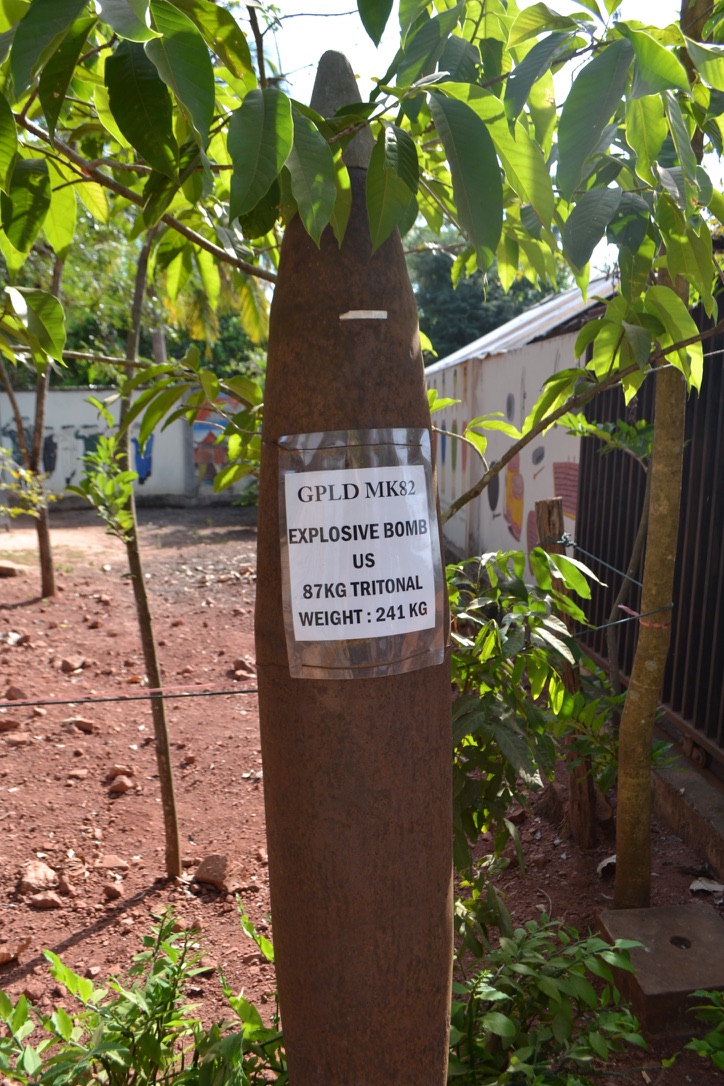 A defused 241 kilogram US MK82 bomb casing stands upright in the museum garden with its label